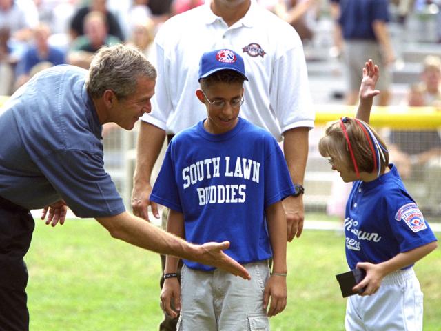 President George W. Bush high-fives players during a tee ball game
